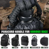 A black paracord handle with a metal hook is shown being used to secure various tactical bags and backpacks.