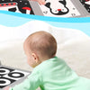 A baby is looking into a flash card mirror while interacting with high contrast baby flash cards.