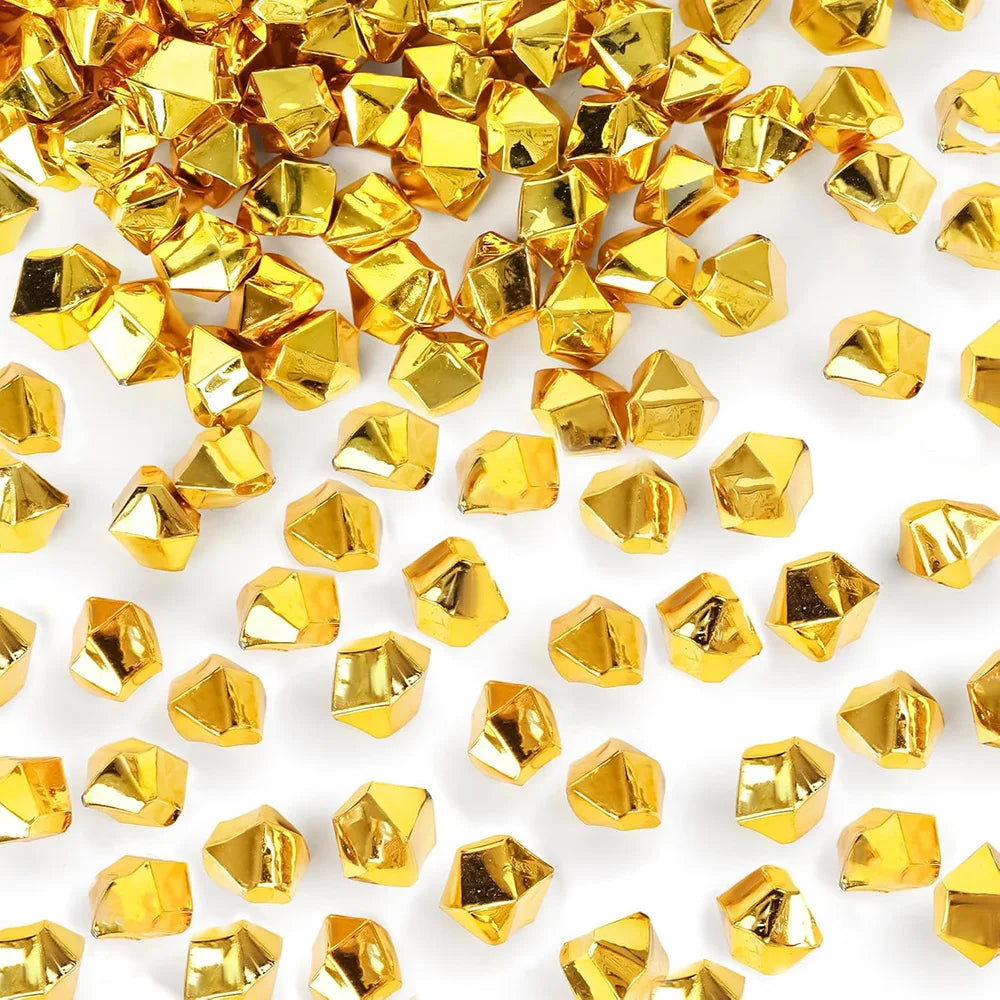 A pile of gold acrylic crushed ice gems used for vase fillers and decor.