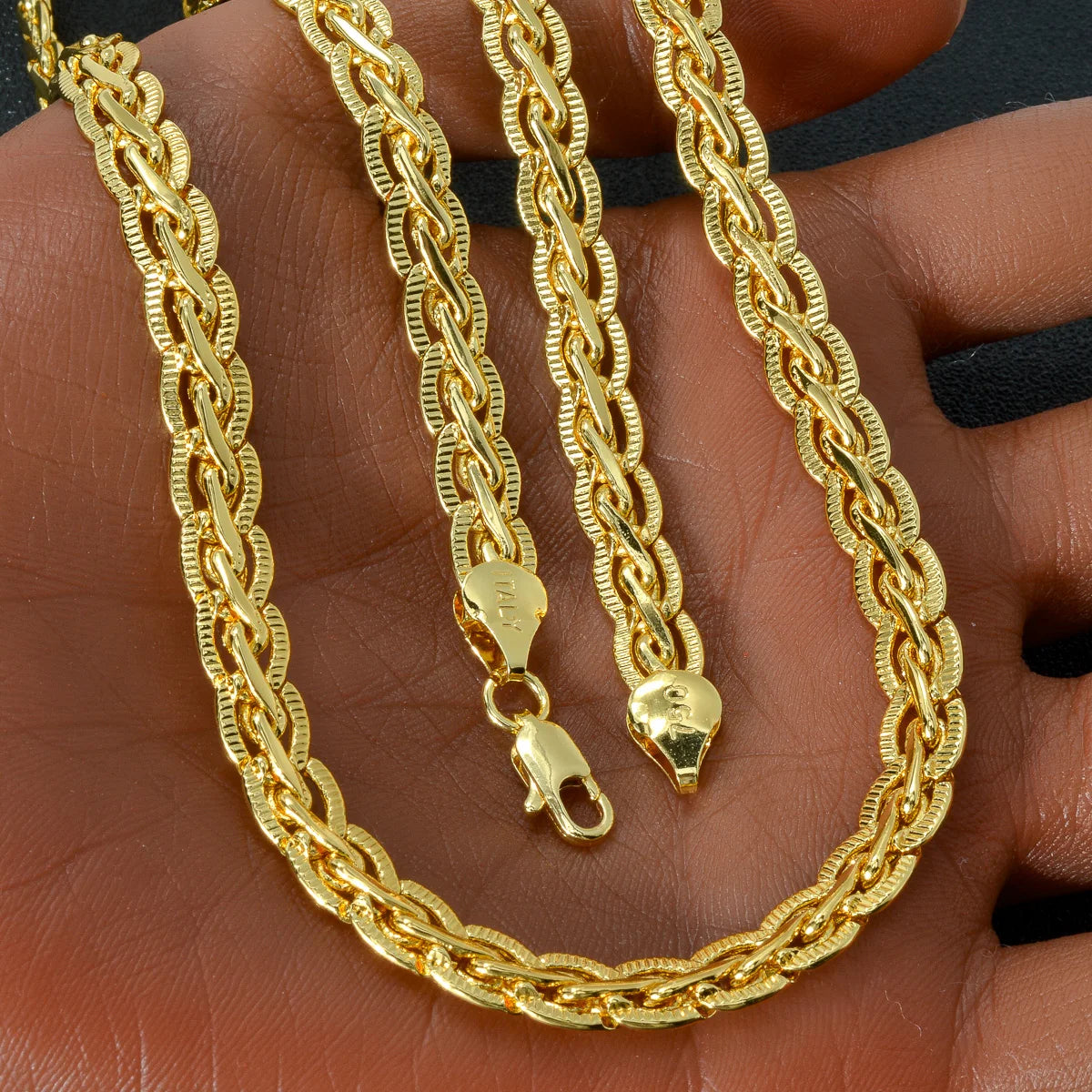 Nahaufnahme einer goldvergoldeten Kettenkette (Cuban Link) als Halskette auf einer Hand.