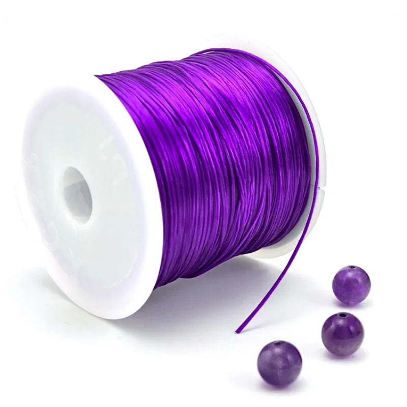 A roll of purple elastic cord for beading and jewelry making with a few loose strands.