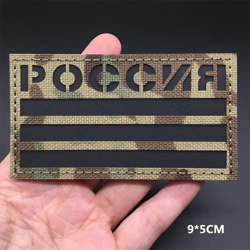 A rectangular tactical patch featuring the Russian flag text and camouflage pattern with hook-and-loop backing.