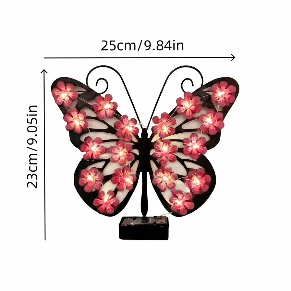 Applique murale papillon noire alimentée par énergie solaire avec accents floraux roses.