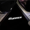 A close-up view of a black LED car door logo projector welcome light for a Toyota 4Runner.