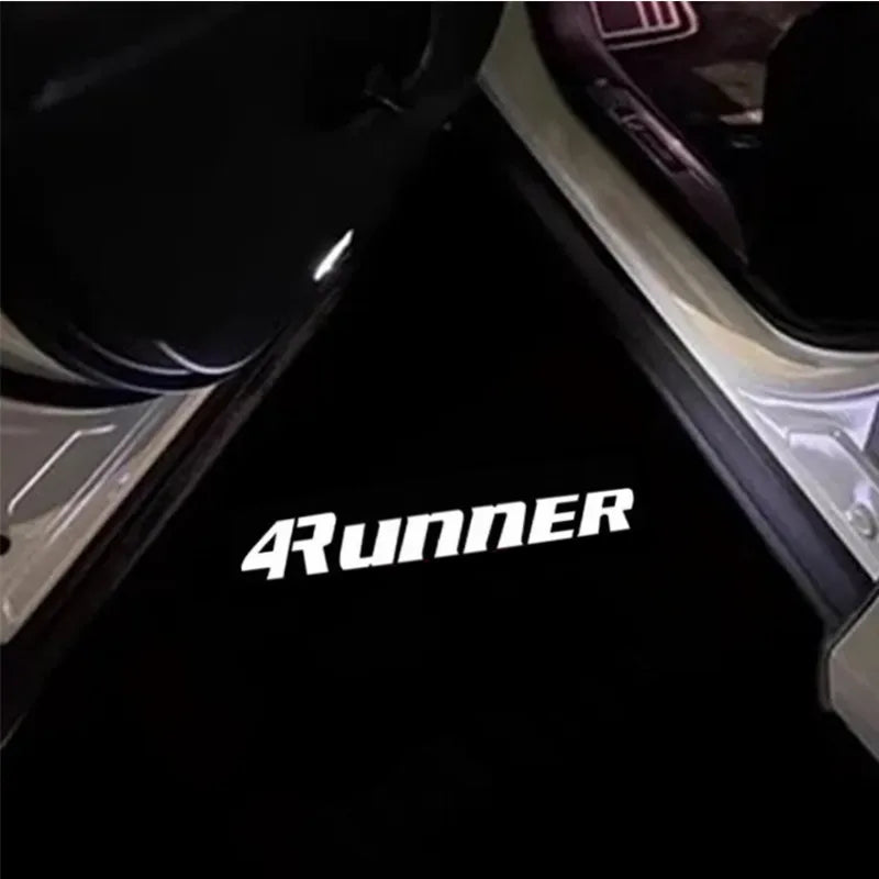 A close-up view of a black LED car door logo projector welcome light for a Toyota 4Runner.