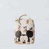 A white backpack featuring Mickey Mouse graphics and a cow print pattern.