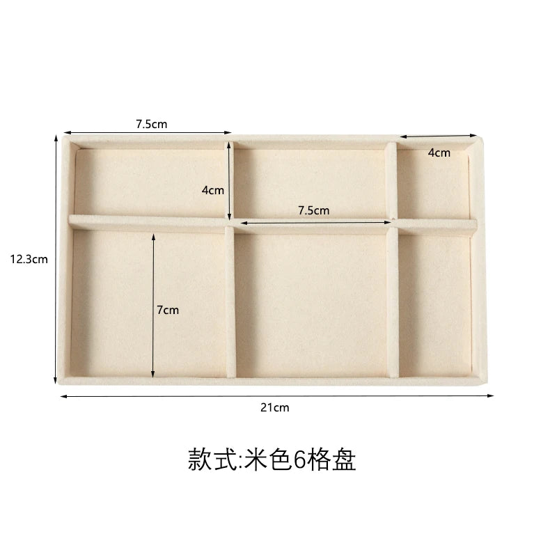 A light beige velvet jewelry organizer tray with six detachable compartments.