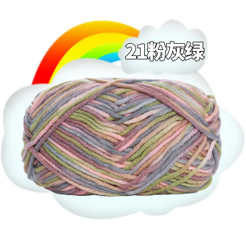 A ball of multi-colored milk cotton blend yarn with pink, green, and gray threads is shown against a white cloud background.