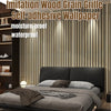 A close-up of imitation wood grain self-adhesive wallpaper installed as vertical stripes on a modern wall behind a bed.
