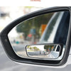 A close-up view of a car's side mirror showing a reflection of a street and surrounding environment.