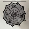 A black disposable spider web Halloween table runner or placemat set.