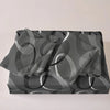 A set of three geometric print duvet covers and pillowcases in shades of gray and white.