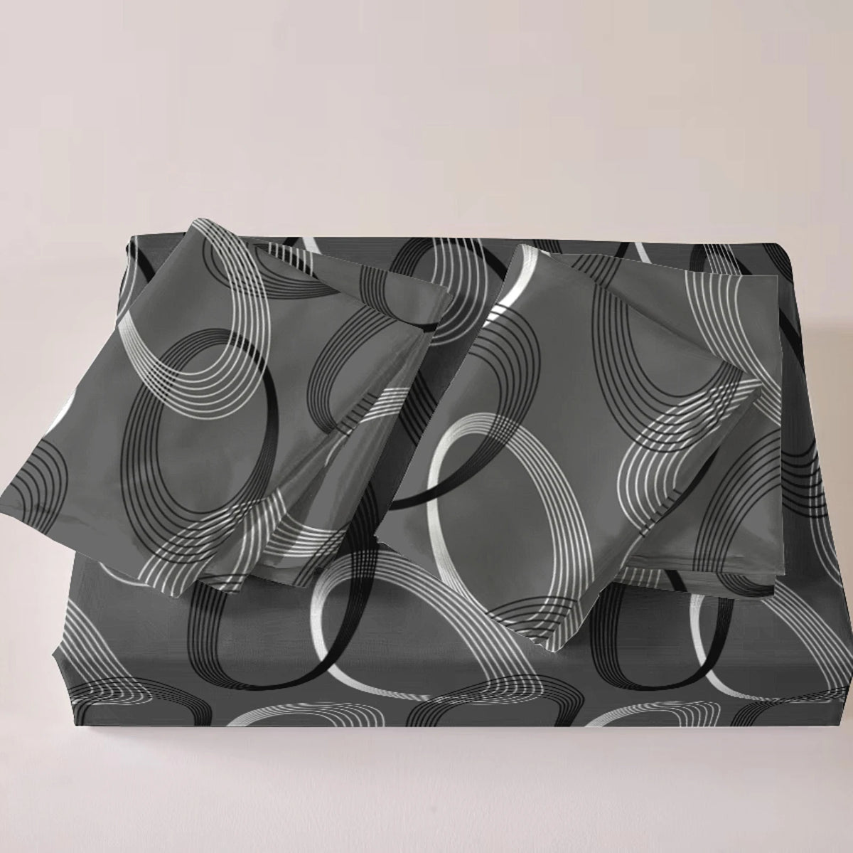A set of three geometric print duvet covers and pillowcases in shades of gray and white.