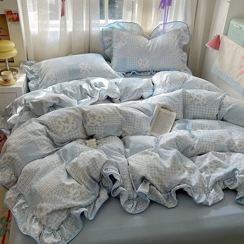 A light blue floral duvet cover set with matching pillowcases and a flat sheet displayed on a bed.
