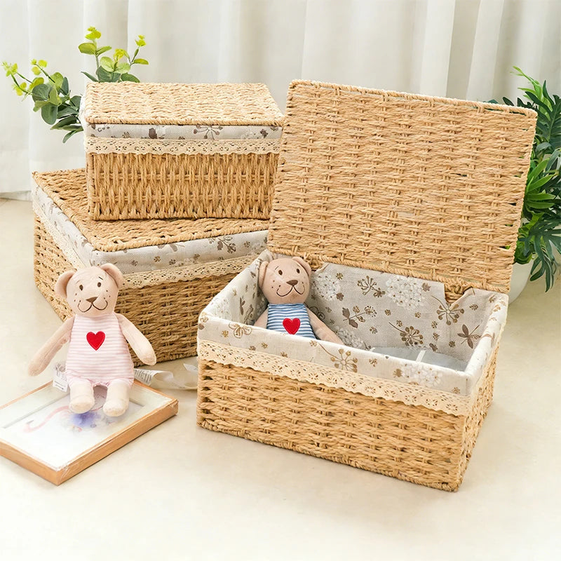 A stack of handwoven rattan storage baskets, some open revealing interiors with decorative paper, and a single basket lying o