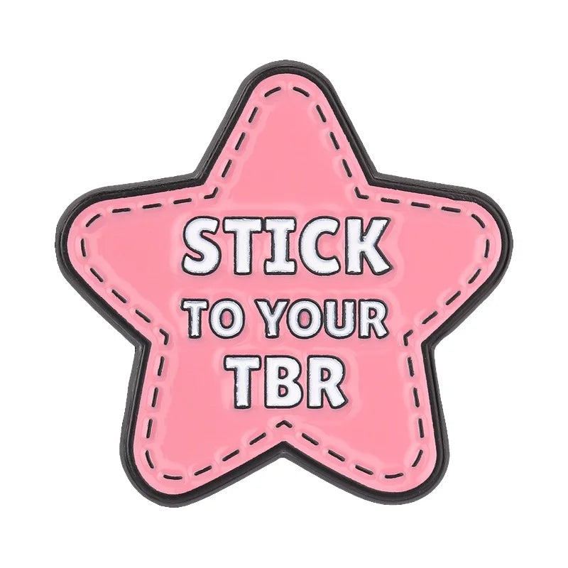 Pink star-shaped enamel pin with the text Stick to your TBR