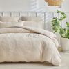 A beige embossed leaf pattern microfiber duvet cover set displayed on a bed with white headboard.