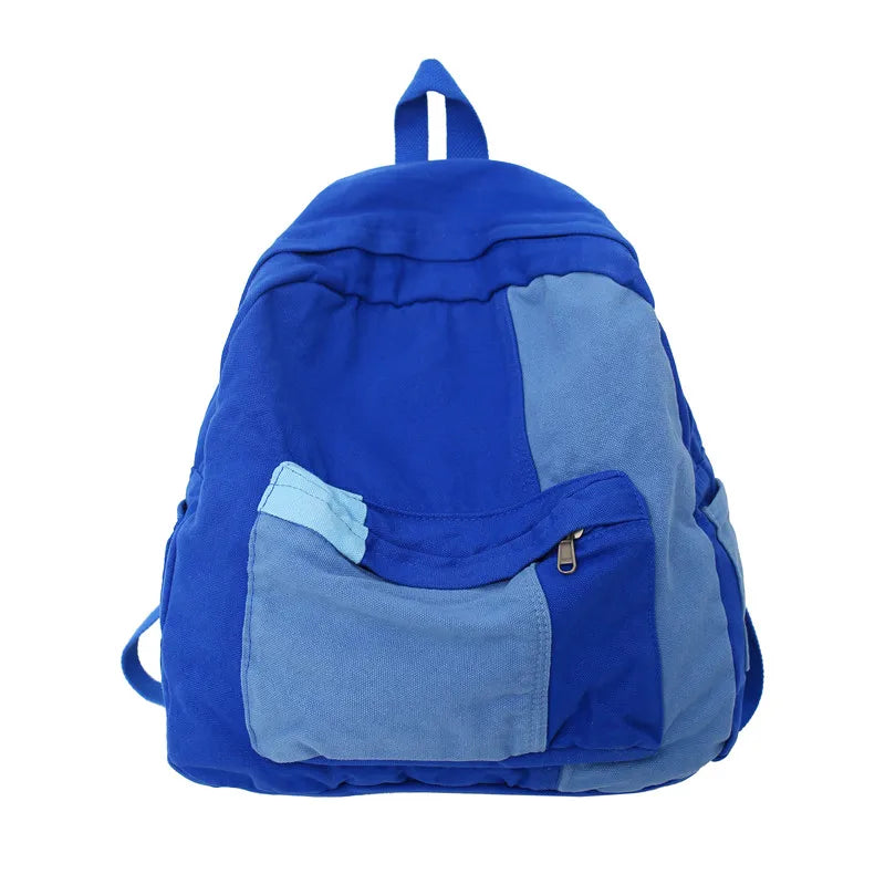 A royal blue canvas patchwork backpack with gray accents.