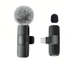 A black USB-C wireless lavalier microphone with a gray faux fur windscreen and a rectangular body.