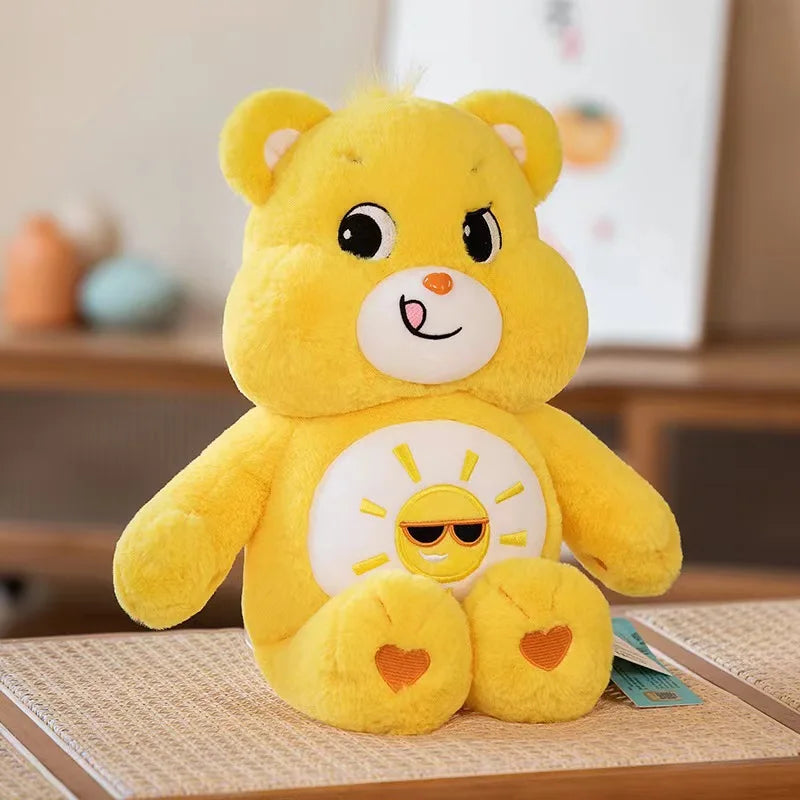Peluche Kawaii de Care Bears arcoíris amarillo con cara sonriente y diseño de sol.