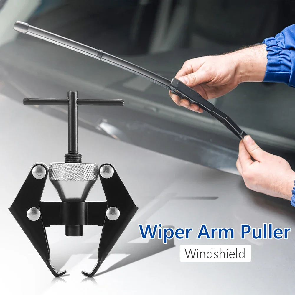 A hand is using a wiper arm puller tool to remove a windshield wiper blade.