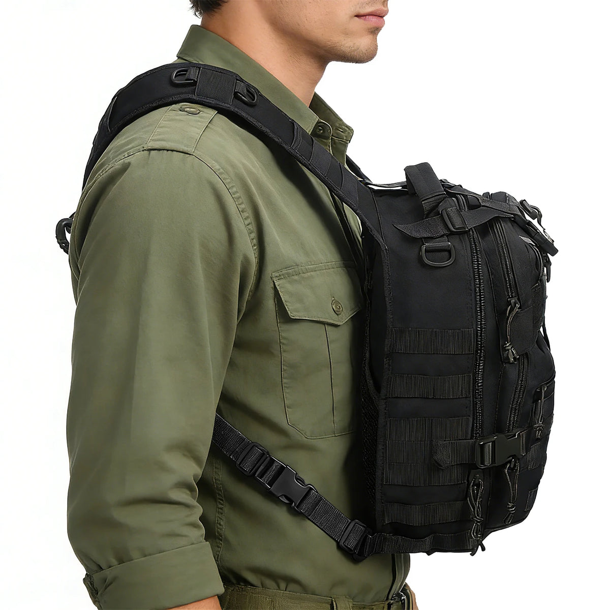 A close-up of a person wearing a olive green shirt and a black crossbody chest bag with multiple zipper compartments and a MO