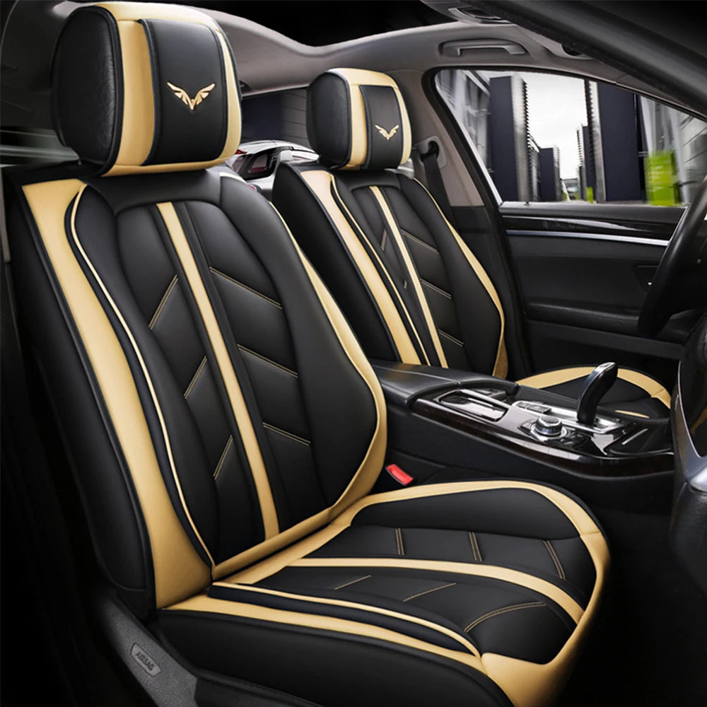 Black car seat covers with tan stitching and gold emblems installed in a vehicle interior.