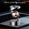 Shiny silver rose gold magnetic levitating spinning top resting on a laptop keyboard