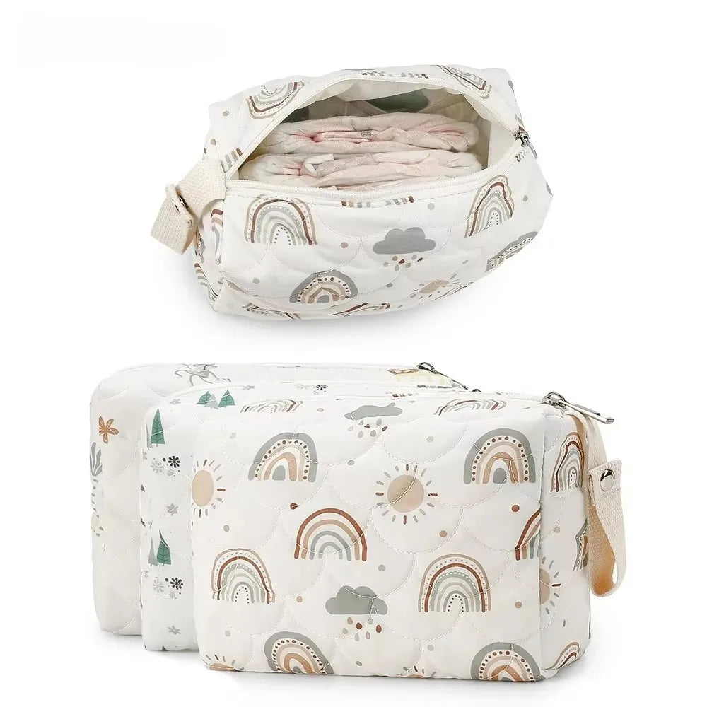 A white fabric diaper caddy organizer with a rainbow print featuring clouds and sun motifs, holding baby diapers.