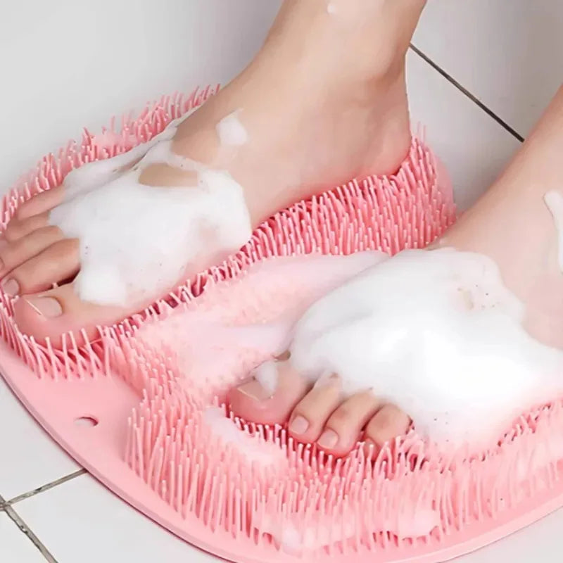 A pink suction cup foot massage mat with exfoliating bristles is being used on a person's foot.