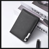 A black slim vertical leather wallet with a silver clasp resting on a white surface next to a magazine.