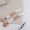 A personalized silicone pacifier clip with a name and anti-drop lanyard featuring white and natural wood elements.