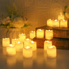 A collection of glowing white LED tea lights arranged on a wooden surface next to a rustic tray and floral arrangement.