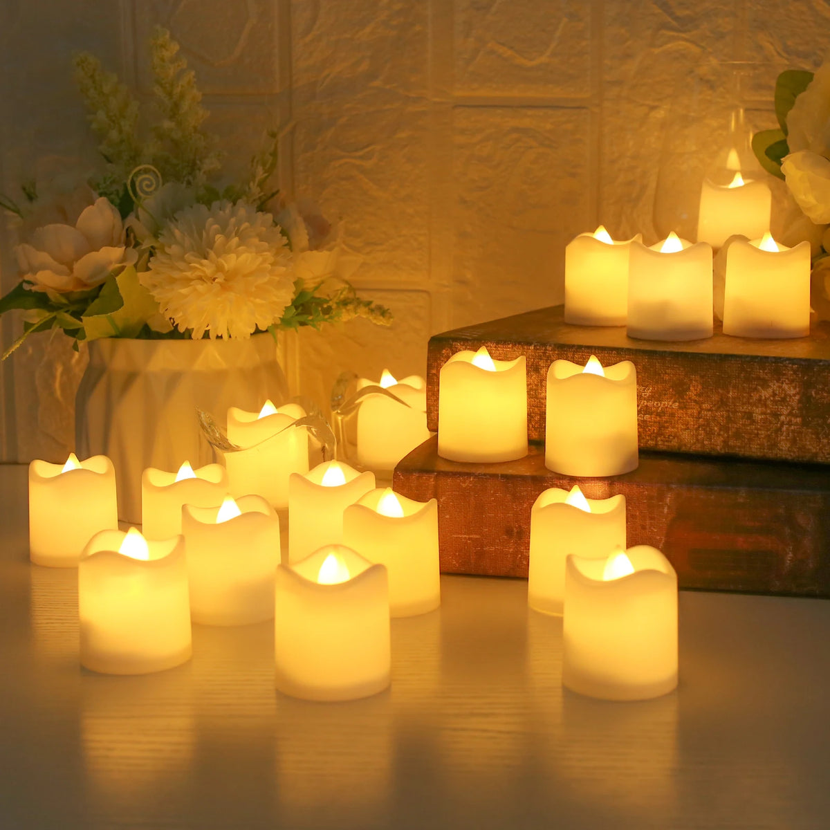 A collection of glowing white LED tea lights arranged on a wooden surface next to a rustic tray and floral arrangement.