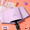 A pink automatic compact umbrella with a black handle is shown open on a peach-colored background.