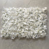 A dense wall panel made of white silk rose flowers for weddings and events