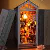 A miniature DIY book nook kit featuring a detailed bookshelf room scene with wooden elements and lighting.