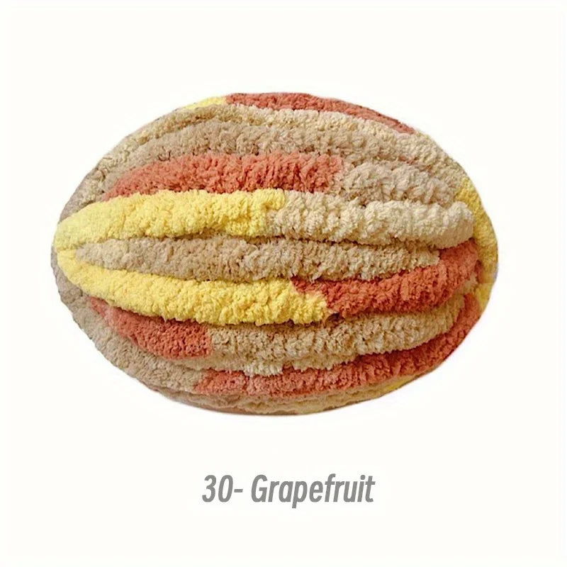 A ball of textured chenille yarn in stripes of peach, yellow, and pink.