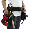 A person is holding a black padded tool belt with red accents and various tools attached.