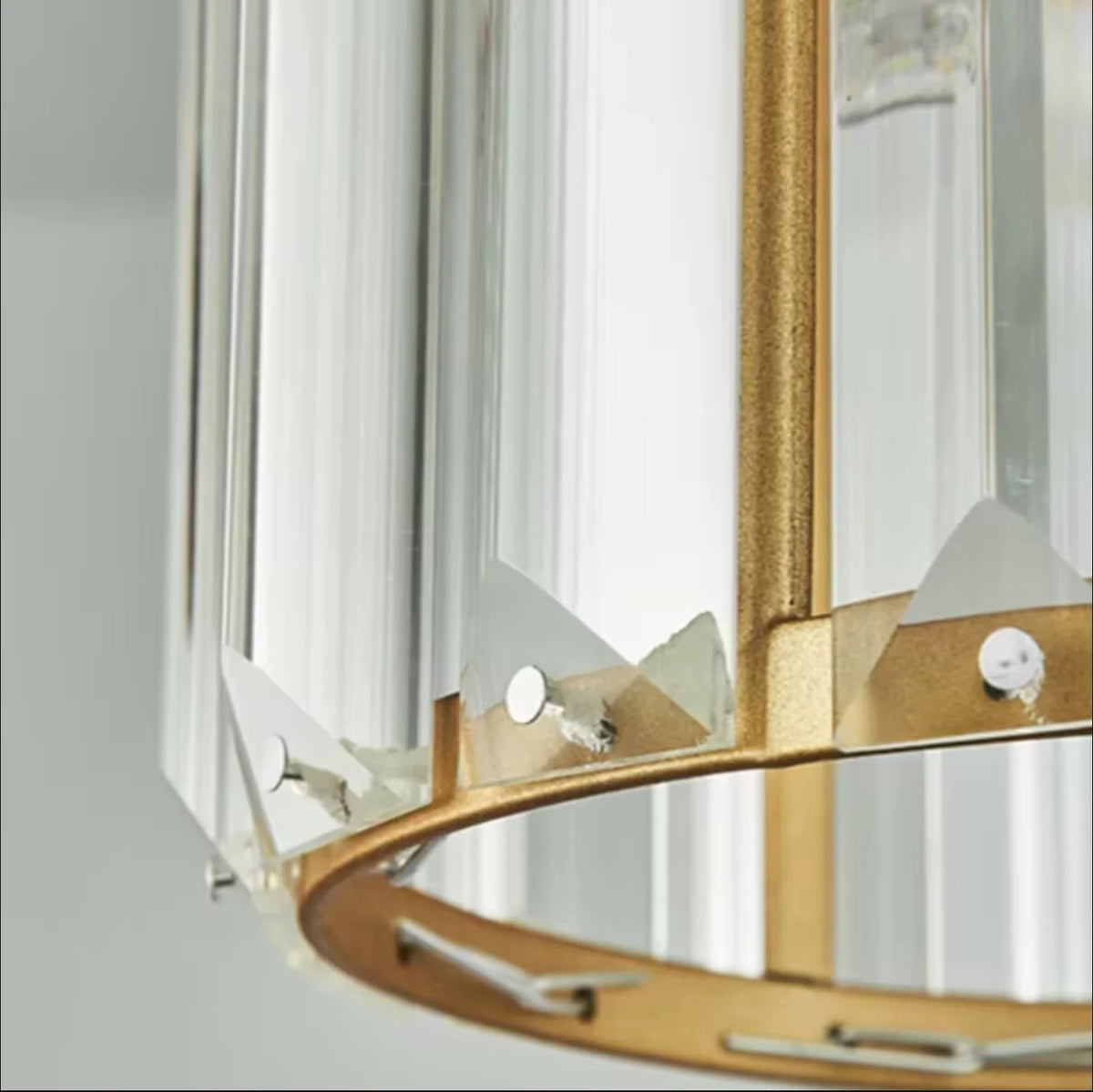 A close-up view of a crystal pendant light with an iron frame and clear glass shade.