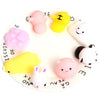 A white plate with eighteen pink and yellow animal squeeze stress relief toys arranged around the edge.
