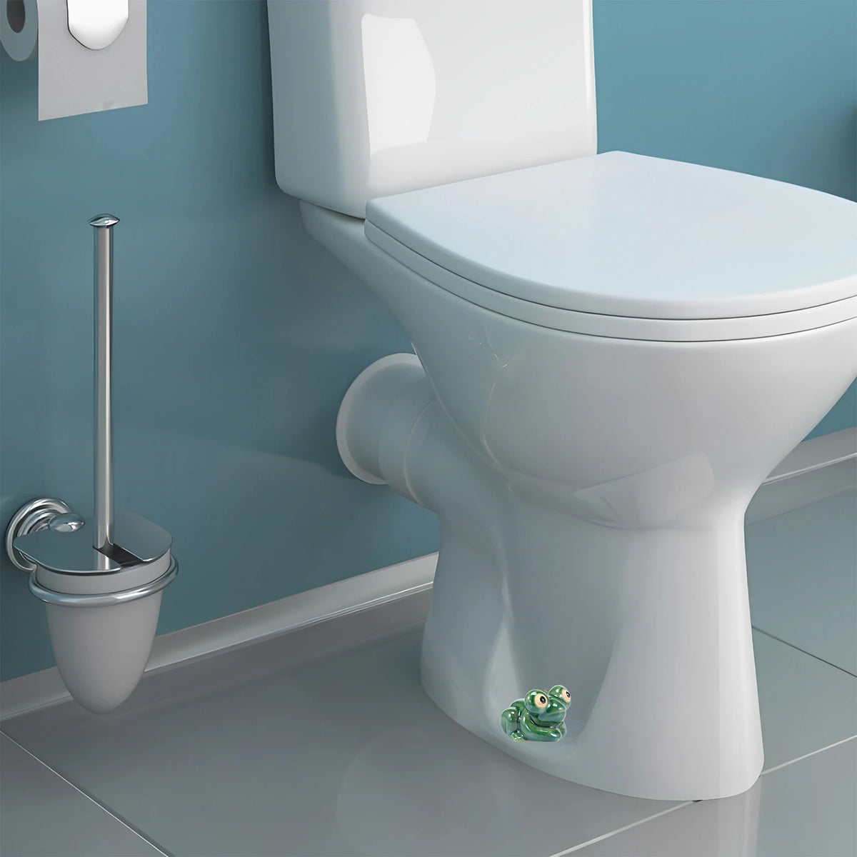 A white ceramic toilet with a hand-painted green frog bolt cover on the base.
