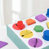 A wooden geometric shape and color sorting box filled with colorful blocks for toddlers.