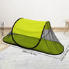 A lime green pop-up mosquito net tent with a black frame and shade canopy shown lying flat.