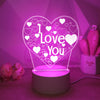A glowing pink heart LED night light with a white 'I Love You' design displayed on a surface.