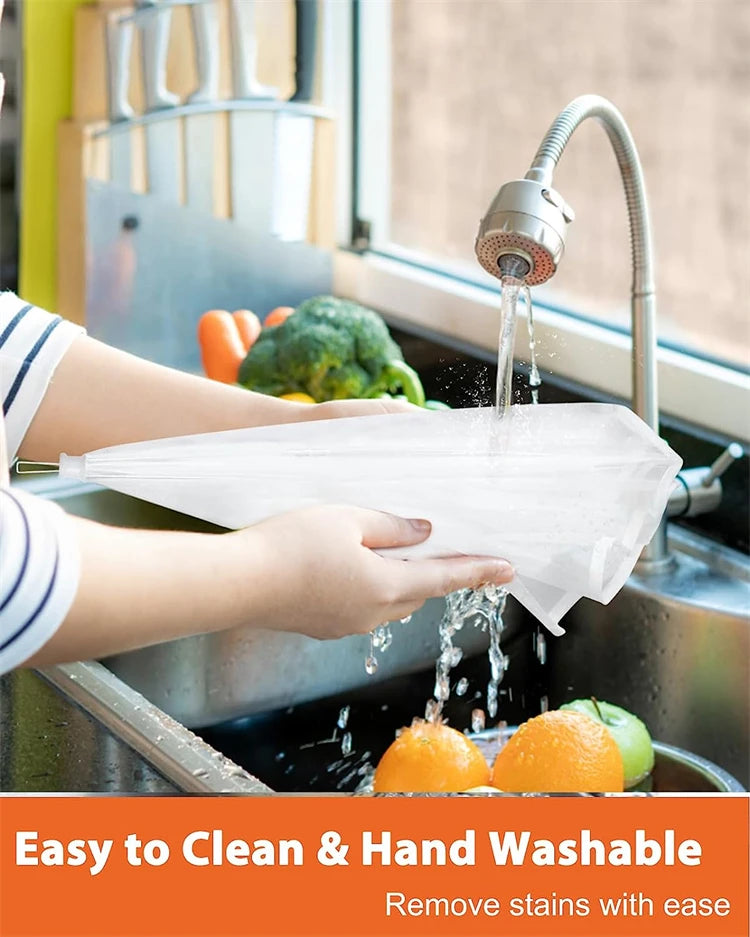 A hand is using a collapsible mesh food cover to wash fruits and vegetables under a kitchen faucet.