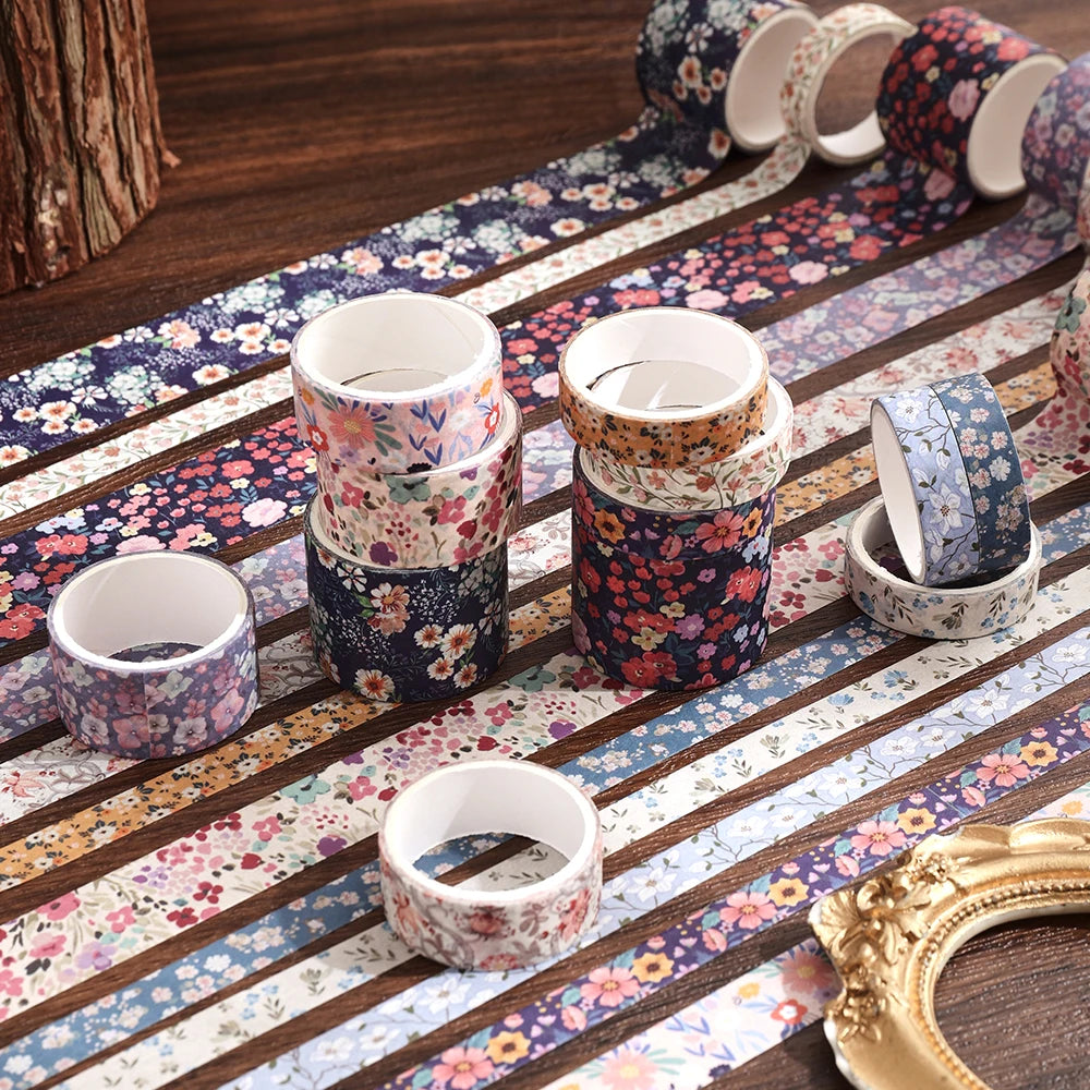 Un ensemble de rouleaux de ruban washi floral vintage disposés sur une surface en bois avec des bandes à motifs.