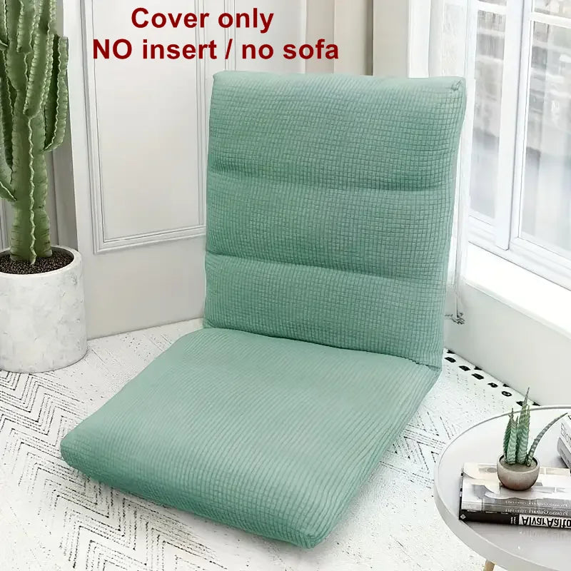 A teal foldable floor sofa cover for a single seat is displayed next to a window and a potted cactus.