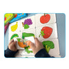 A child's hands are assembling a puzzle featuring various colorful fruits and vegetables like apples, strawberries, corn, and