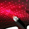 A portable LED projection lamp is shining red light onto the ceiling of a car interior.